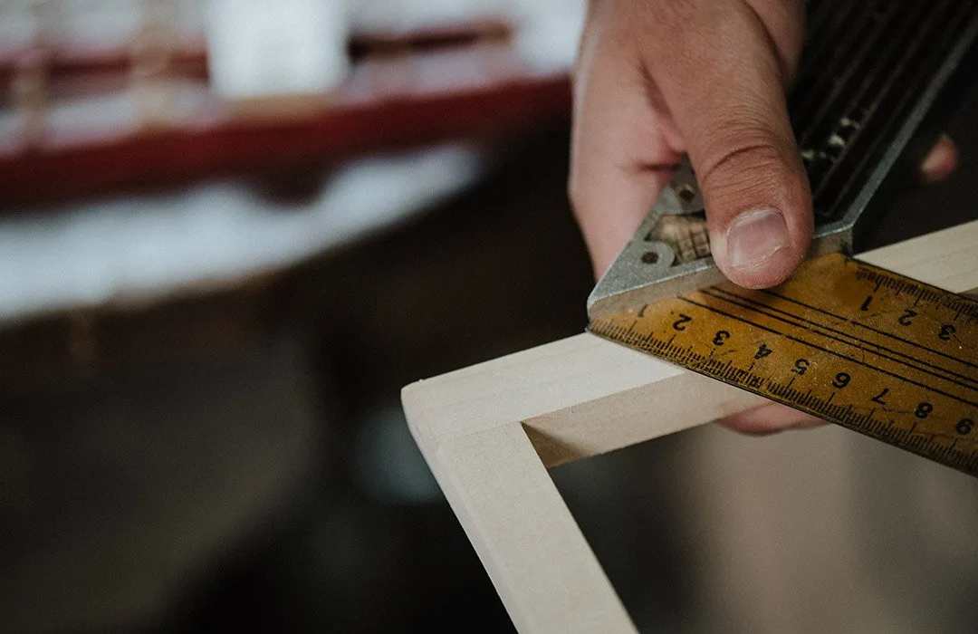 Carpenter precisely measuring the fit of a wood frame