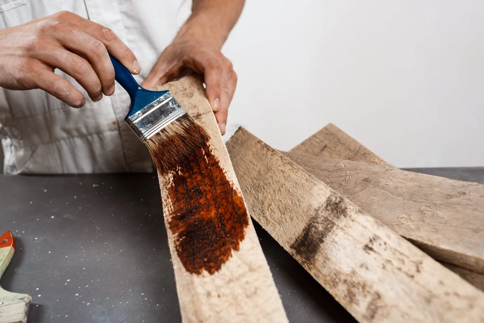Applying wood stain to boards with a brush